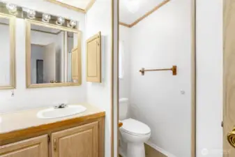 The primary bathroom has double sinks with windows that face the backyard. The shower is opposite the commode.