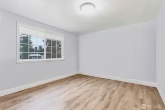 Family room/Bonus Room has been virtually decluttered, removing moving boxes. Room included electrical panel on far wall (not shown).