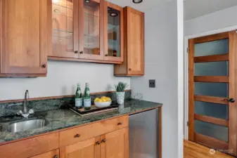 Wet bar with extra cabinetry and beverage fridge.