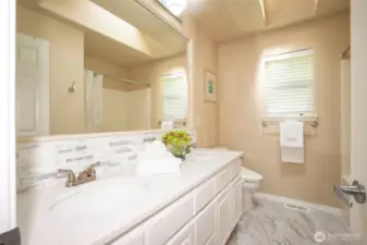Upstairs Hall Bath with Double Sinks & Stone Counters & Tub/Shower Enclosure & Tile Floors.