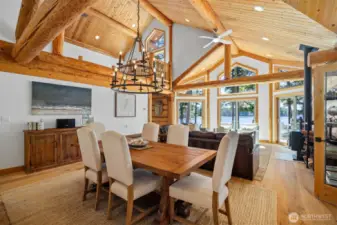 Soaring ceilings and oversized log beams frame this elegant dining space, where panoramic ocean views and warm wood textures create a stunning setting for elevated entertaining.