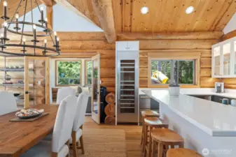 A full-height wine fridge, crisp white quartz counters, and breathtaking ocean outlooks enhance the kitchen’s functionality and luxury, while French doors open to a coastal lounge for effortless flow.