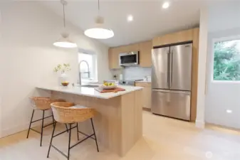 Spacious kitchen with large quartz counters, stainless steel appliances and Bellmont cabinetry.