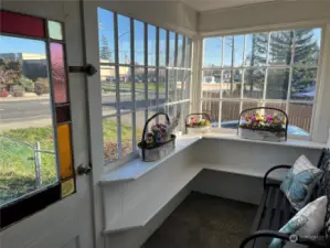 A Victorian sunroom with a stained glass door evokes a sense of timeless elegance and charm. This space is bathed in natural light, with the sun pouring through the intricately designed stained glass, casting colorful patterns across the room.