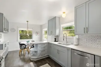 Updated kitchen boasts quartz countertops, undermount sink, stainless steel appliances, with a little rounded corner nod to the Mid Century era.