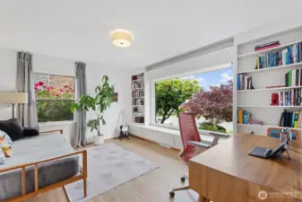 3rd bedroom on the main floor with large picture window to take in little Sound views, built-in bookshelves that surround, and period detail storage that runs the length of the long wall.
