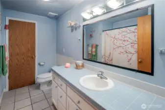 Full hall bath has tile floors and tile counters.