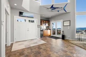 Stepless entry gets you in through double doors.  A wet bar, convenient to patio access through French doors,  has a sink, beverage refrigerator and cabinetry for your needs.  (Sail fish does not convey)