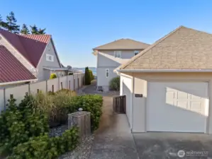 Entrance on the left- beyond the garage, through the gate