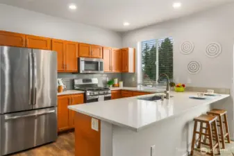 This kitchen has been totally updated. It used to have an elevated wall/bar that was removed and updated to be a large eating bar with quartz counters