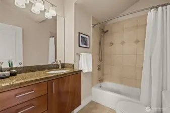 En suite bathroom with wall tiling and tub insert