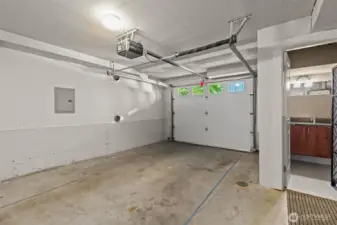 Spacious attached garage with extra storage and access to half-bath