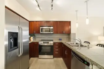 Granite and stainless kitchen with tile flooring