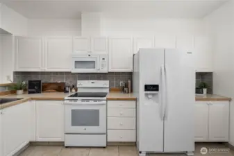 Kitchen has a computer desk to the right and a beautiful storage cabinet out of view.
