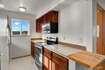 Galley style kitchen has lots of natural light and ample workspace.