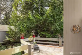 Walk up three stairs to this open air section of the homes entry. Our Seller used this lovely setting for all Four Seasons! The forest like setting is truly unique.