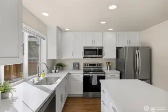 Experience the ultimate in modern living with an open-concept family room and kitchen designed for connection. Bathed in bright, natural light, this expansive space feels both grand and incredibly welcoming.  ?The brand-new kitchen—boasting modern finishes and a functional layout—flows effortlessly into the cozy family room, making it the perfect hub for daily life or weekend entertaining. At the center of it all, a warm gas fireplace serves as a stunning focal point, offering the perfect glow for chilly PNW evenings. Whether you're prepping a meal or relaxing on the sofa, this sun-drenched sanctuary is where your best memories will be made.