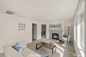 Experience the ultimate in modern living with an open-concept family room and kitchen designed for connection. Bathed in bright, natural light, this expansive space feels both grand and incredibly welcoming.  ?The brand-new kitchen—boasting modern finishes and a functional layout—flows effortlessly into the cozy family room, making it the perfect hub for daily life or weekend entertaining. At the center of it all, a warm gas fireplace serves as a stunning focal point, offering the perfect glow for chilly PNW evenings. Whether you're prepping a meal or relaxing on the sofa, this sun-drenched sanctuary is where your best memories will be made.