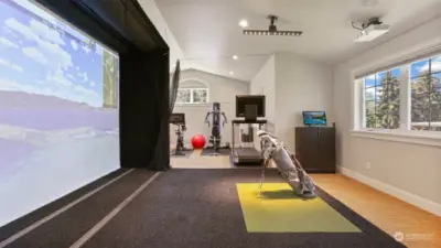 Upstairs bonus room with a golf simulator and an additional flex space currently serving as a gym with an adjacent full bath. (not pictured)