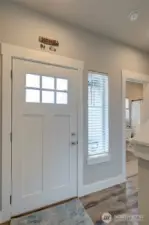 A warm entry in the home leads to main floor suite, as well as living room and dining/kitchen area.