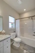 Main floor full bathroom is accessible from the family room/bedroom as well as the hallway.