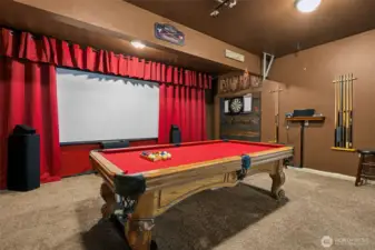 Welcome to the ultimate entertainment cave. With plush carpeting, a theater-style setup with red curtains and a screen, and a pool table all included, this converted garage is more than just a space, it’s a whole vibe. Movie night? Pool game? It’s all here.