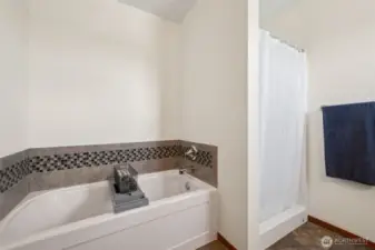 When you’re ready to unwind, this primary suite bath has you covered. Deep soaking tub with a glass tile-accented backsplash for those spa vibes, plus a shower that’s just waiting for you to step in. Add in the vinyl flooring, and you’re looking at the perfect mix of comfort and convenience.