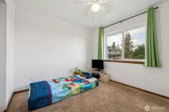 Light, bright, and cozy, this second bedroom features light brown carpet, a large window for natural light, and a white ceiling fan to keep things cool. It’s the perfect spot for whatever you need: sleep, study, or relaxation.