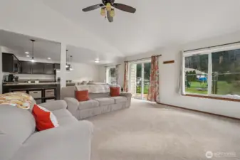 This is the kind of living room that plays it cool but knows it's the star. Oversized windows serve backyard views all day, the ceiling fan is on standby for drama control, and the open layout says “go ahead, multitask.” It’s cozy, it’s functional, and it already knows where your favorite chair will go.