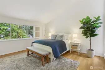 Upper level primary bedroom with vaulted ceilings and peek-a-boo mountain views.