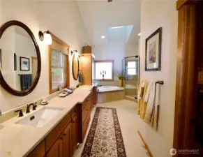 Spa bathroom w/ double vanity and large walk-in closet.