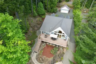 Gorgeous view of large deck and stairway leading to lake surrounded by beautiful landscape!
