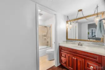 The bathroom vanity offers good storage, and the bathroom has been updated with a tile surround.