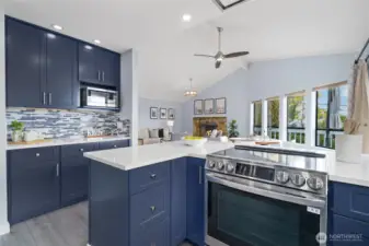 New kitchen with beautiful navy cabinets, quartz, designer tile, induction range, special vent hood flush to the ceiling and coffee bar!
