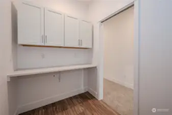 The Utility Room features ample cabinetry for storage, great counterspace for folding laundry and LVP flooring.