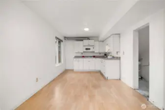 This area works as a dining area for a smaller table and chair set. The doorway on the right houses the water heater for the basement and offers storage options.