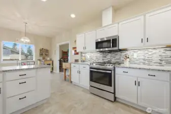 Propane Gas Range, Microwave above, Glass tile backsplash, Granite Counter tops, Iron handles, Under cabinet lighting, vinyl flooring- a practical choice for little people or pets.