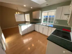 Beautiful and fresh with a great gleam to those floors. Storage for all culinary projects should not be a problem here. Yes, that’s a dishwasher to the left of the sink and on the right is a corningware style cooktop… do they still call them that?