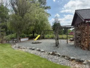 Swing set, fire pit and wood shed.