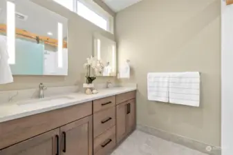 Spa-like primary bath boasts dual vanities & LED mirrors, with bluetooth, heated floor & natural light.