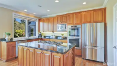 Cherry cabinetry, high-end appliances including Miele, Samsung, and KitchenAid, walk-in pantry, and under-cab lighting