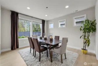 Dining area filled with natural light – drapery included.