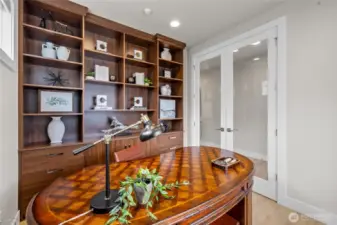 Custom shelving and cabinetry in the office add style and functionality.  Dedicated office with French doors and custom built-ins – desk and chair included.