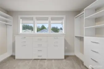 Closet features built-ins, drawers, and dual hampers.