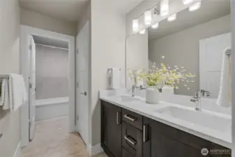 Full bath with double vanity and separate shower/toilet area.