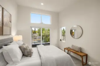 The primary bedroom is a sanctuary of natural light, featuring vaulted ceilings, large windows, and private balcony access. Wake up to serene views and unwind in your peaceful haven.