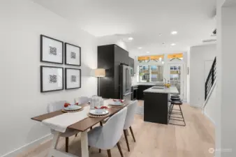 Gather around this dining space, where modern simplicity meets thoughtful design. Adjacent to the sleek kitchen, it offers a perfect setting for meals shared with loved ones, enhanced by warm natural tones and abundant lighting.