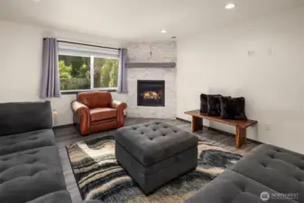 Living room with large windows and gas fireplace.