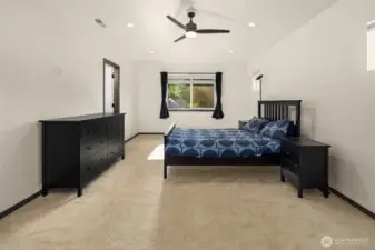 Primary bedroom with large windows overlooking the backyard.
