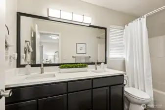 Primary en-suite with new sinks, faucets, mirror, lighting and quartz counters